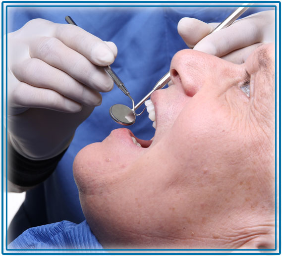 Dentist cleaning a mans teeth